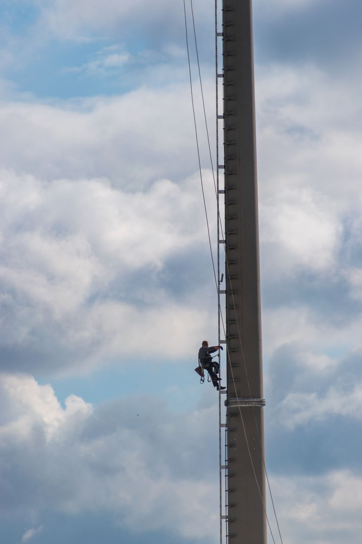 Höhenarbeiter beim Aufstieg an einem Antennenmast zur Inspektion